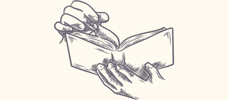 Ein kleines Buch, das von einer hand gehalten wird. Die andere blättert eine Seite um.